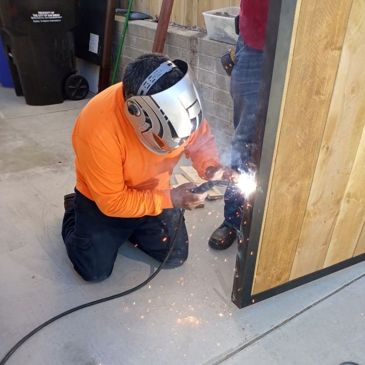 man welding an iron gate